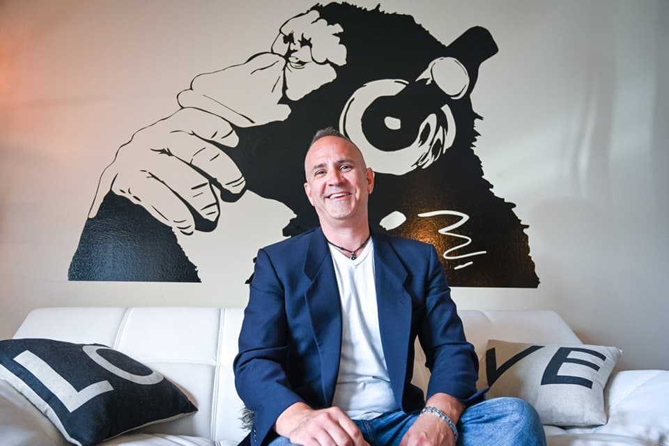 David Brown in front of a Banksy art piece.